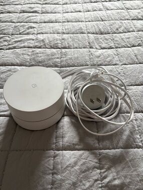 Google white Wi‑Fi puck router with matching power cable